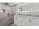 Bathroom with glass shower, pebble floor, and double sink vanity with lighted mirror at 608 Cedar Ave, Holly Hill, FL 32117