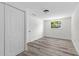 Bedroom with wood-look flooring, closet, and bright window at 608 Cedar Ave, Holly Hill, FL 32117