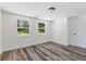 Light-filled bedroom with wood-look floors, neutral walls, a closet, and two windows offering natural light at 608 Cedar Ave, Holly Hill, FL 32117