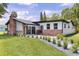 Charming home featuring a brick chimney, complemented by a lush green lawn and modern landscaping at 608 Cedar Ave, Holly Hill, FL 32117