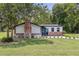 Quaint home boasting a brick chimney, beautiful lawn, and a pop of color with its bright blue door at 608 Cedar Ave, Holly Hill, FL 32117
