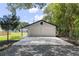 Detached two car garage with white exterior and black trim contrasted against a gravel and concrete driveway at 608 Cedar Ave, Holly Hill, FL 32117