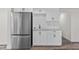 Kitchenette featuring stainless refrigerator, white cabinets, marble countertops, and subway tile backsplash at 608 Cedar Ave, Holly Hill, FL 32117