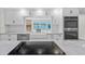 Modern kitchen with white cabinets, stainless appliances, and granite countertop island at 608 Cedar Ave, Holly Hill, FL 32117