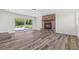 Living room with wood-look floors, fireplace and a large window offering outdoor view at 608 Cedar Ave, Holly Hill, FL 32117