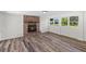 Bright living room featuring a brick fireplace and wood-look floors at 608 Cedar Ave, Holly Hill, FL 32117