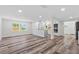 Bright open-concept living area with updated kitchen and wood-look floors at 608 Cedar Ave, Holly Hill, FL 32117
