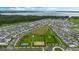 Aerial view of a community featuring lush green spaces, a lake, and a variety of amenities at 6449 Sprucepine Ln, St Cloud, FL 34771