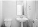 Bathroom with a pedestal sink, toilet, mirror, and chrome fixtures at 6449 Sprucepine Ln, St Cloud, FL 34771