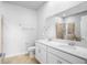 Bright bathroom featuring double sink vanity with white cabinets and large mirror, with a shower and toilet visible at 6449 Sprucepine Ln, St Cloud, FL 34771
