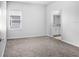 A carpeted bedroom featuring a window with blinds and a doorway leading to an adjacent bathroom at 6449 Sprucepine Ln, St Cloud, FL 34771