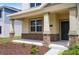 Charming covered porch with stone pillars, leading to a welcoming entrance of a two-story home at 6449 Sprucepine Ln, St Cloud, FL 34771
