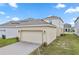 View of a two car garage with exterior lights and a brick paver driveway at 6449 Sprucepine Ln, St Cloud, FL 34771
