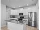 Modern kitchen with white cabinetry, stainless steel appliances, gray countertops and a kitchen island at 6449 Sprucepine Ln, St Cloud, FL 34771