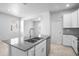 Kitchen island features a double sink, gray countertops, and white cabinets at 6449 Sprucepine Ln, St Cloud, FL 34771