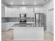 Bright kitchen features stainless steel appliances, gray countertops and white cabinets at 6449 Sprucepine Ln, St Cloud, FL 34771