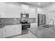 Modern kitchen boasts stainless steel appliances, gray countertops, and white cabinetry at 6449 Sprucepine Ln, St Cloud, FL 34771