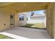 A covered patio in backyard, with a concrete flooring and walls painted in neutral colors at 6449 Sprucepine Ln, St Cloud, FL 34771