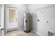 A neutral utility room with a water heater, shelving, and a door leading to the backyard at 6449 Sprucepine Ln, St Cloud, FL 34771