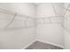 A walk-in closet featuring carpeted floors, white walls, and built in shelving to maximize storage space at 6449 Sprucepine Ln, St Cloud, FL 34771