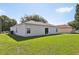 Backyard showing the home's exterior, manicured green lawn and some neighborhood views at 702 Pasteur Ln, Kissimmee, FL 34759