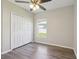 Bedroom featuring a closet, wood-look floors, a ceiling fan and a window at 702 Pasteur Ln, Kissimmee, FL 34759