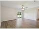 Bright living room featuring modern wood-look floors and a sliding glass door at 702 Pasteur Ln, Kissimmee, FL 34759