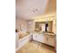 Well-lit bathroom featuring granite counters, a soaking tub, and a double vanity at 813 Marsh Reed Dr, Winter Garden, FL 34787