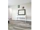 Neutral bedroom with wood laminate flooring, white console table, and framed mirror at 813 Marsh Reed Dr, Winter Garden, FL 34787