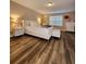 Bright bedroom featuring stylish, wood-look floors, and a luxurious white bed frame at 813 Marsh Reed Dr, Winter Garden, FL 34787