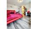 Modern bedroom featuring red bed, laminate floors, and accent lighting at 813 Marsh Reed Dr, Winter Garden, FL 34787