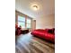Bedroom featuring wood-look flooring, windows, and a red bed at 813 Marsh Reed Dr, Winter Garden, FL 34787