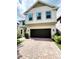 Charming two-story home featuring a neutral paint, brick driveway, two-car garage and manicured bushes at 813 Marsh Reed Dr, Winter Garden, FL 34787