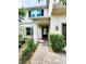 Inviting front entrance featuring a covered porch, beautiful landscaping, and a brick-paved walkway at 813 Marsh Reed Dr, Winter Garden, FL 34787