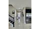 Well-lit hallway featuring tile flooring, staircase and access to the kitchen at 813 Marsh Reed Dr, Winter Garden, FL 34787