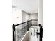 Hallway with wrought iron railing overlooking the staircase with wood laminate floors at 813 Marsh Reed Dr, Winter Garden, FL 34787