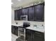 Kitchen with black cabinets, stainless steel appliances, and white countertops with floral decor at 813 Marsh Reed Dr, Winter Garden, FL 34787