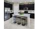 Modern kitchen with stainless steel appliances, granite countertops, and black cabinets at 813 Marsh Reed Dr, Winter Garden, FL 34787