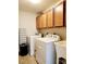 Well-lit laundry room with washer, dryer, utility sink, and wooden cabinets at 813 Marsh Reed Dr, Winter Garden, FL 34787