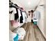 A view of a walk-in closet with hardwood floors and ample storage racks at 813 Marsh Reed Dr, Winter Garden, FL 34787