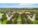 Aerial view of a community center with trees, green spaces, parking and lake in the distance at 911 Tidal Pond Dr, Groveland, FL 34736