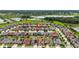 Aerial view of a residential neighborhood with well-maintained homes, green spaces, and a pond in the background at 911 Tidal Pond Dr, Groveland, FL 34736
