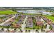 Aerial view of a residential neighborhood with well-maintained homes, green spaces, and a lake in the background at 911 Tidal Pond Dr, Groveland, FL 34736