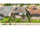 Aerial view of a fenced backyard with professional landscaping, green grass, and a small patio at 911 Tidal Pond Dr, Groveland, FL 34736