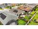 Aerial view of a backyard with professional landscaping, green grass, patio and solar panels on the roof at 911 Tidal Pond Dr, Groveland, FL 34736