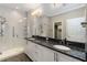 Elegant bathroom featuring dual sinks, granite countertop, a walk-in glass shower, and stylish fixtures at 911 Tidal Pond Dr, Groveland, FL 34736