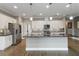 Bright kitchen with white cabinets, stainless steel appliances, island with granite countertop, and mosaic backsplash at 911 Tidal Pond Dr, Groveland, FL 34736