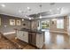 Kitchen island with sink and dishwasher overlooking the living space and sliding glass doors at 911 Tidal Pond Dr, Groveland, FL 34736