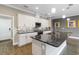 Updated kitchen featuring an island with a sink, granite countertops, white cabinets, and stainless steel appliances at 911 Tidal Pond Dr, Groveland, FL 34736