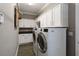 This laundry room is well-equipped with plenty of cabinet space and a newer washer and dryer at 911 Tidal Pond Dr, Groveland, FL 34736